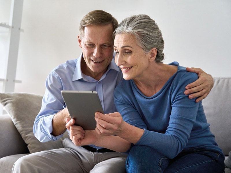 A photo of a smiling couple reviewing their free, no obligation quote on a tablet