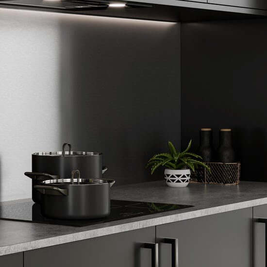 a dark kitchen featuring a light grey marble-style worktop