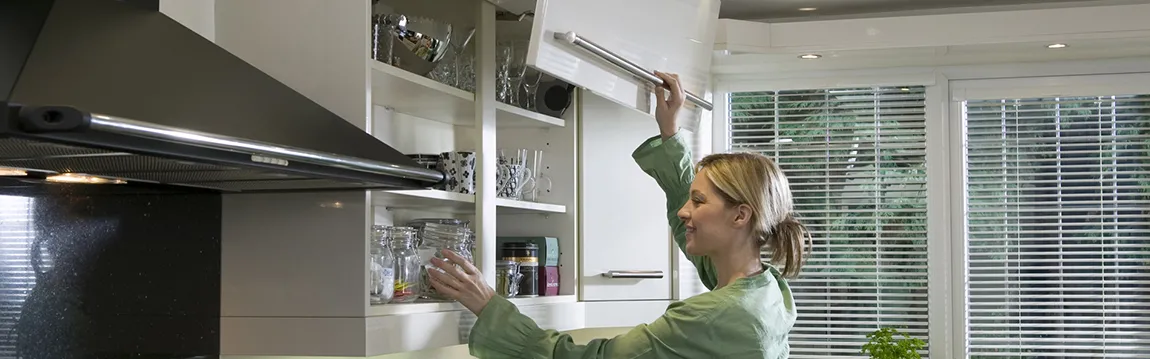 woman using smart storage in high gloss white kitchen