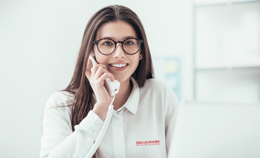 A photo of a smiling customer service representative answering a customer's questions over the phone